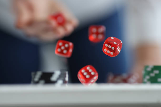 Man throws red dice on table and chips. Casino game and luck